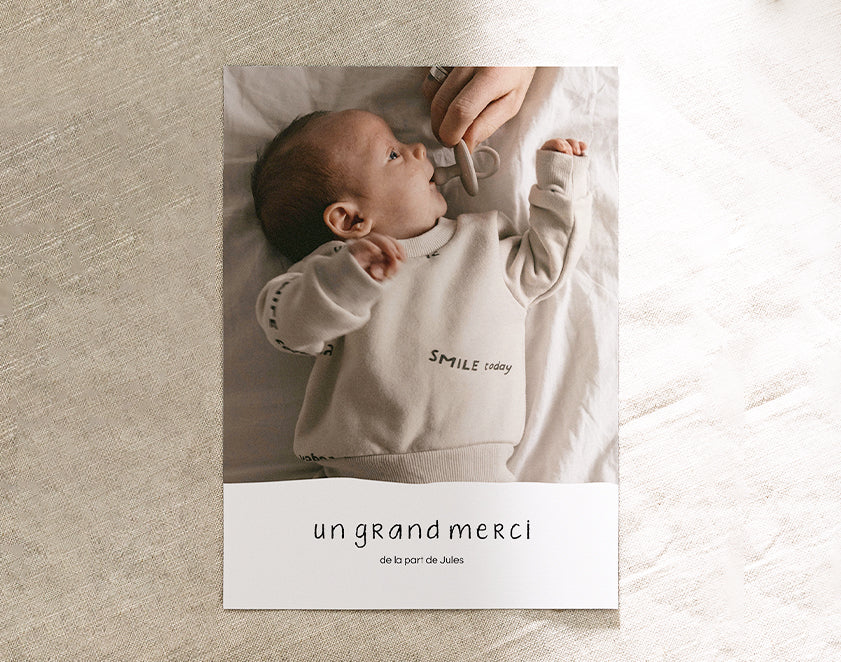 Carte de remerciement naissance simple au format portrait avec la photo d'un bébé et le texte "un grand merci"