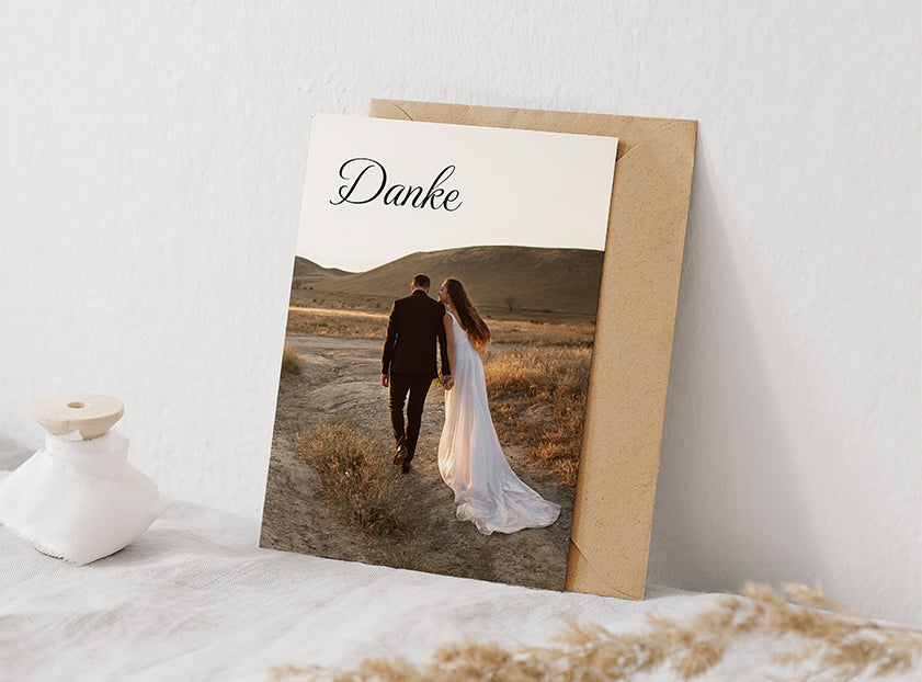 einfache Dankeskarte zur Hochzeit im Hochformat mit einem ganzseitigen Foto von zwei Brautpaaren und dem Text „Danke“.